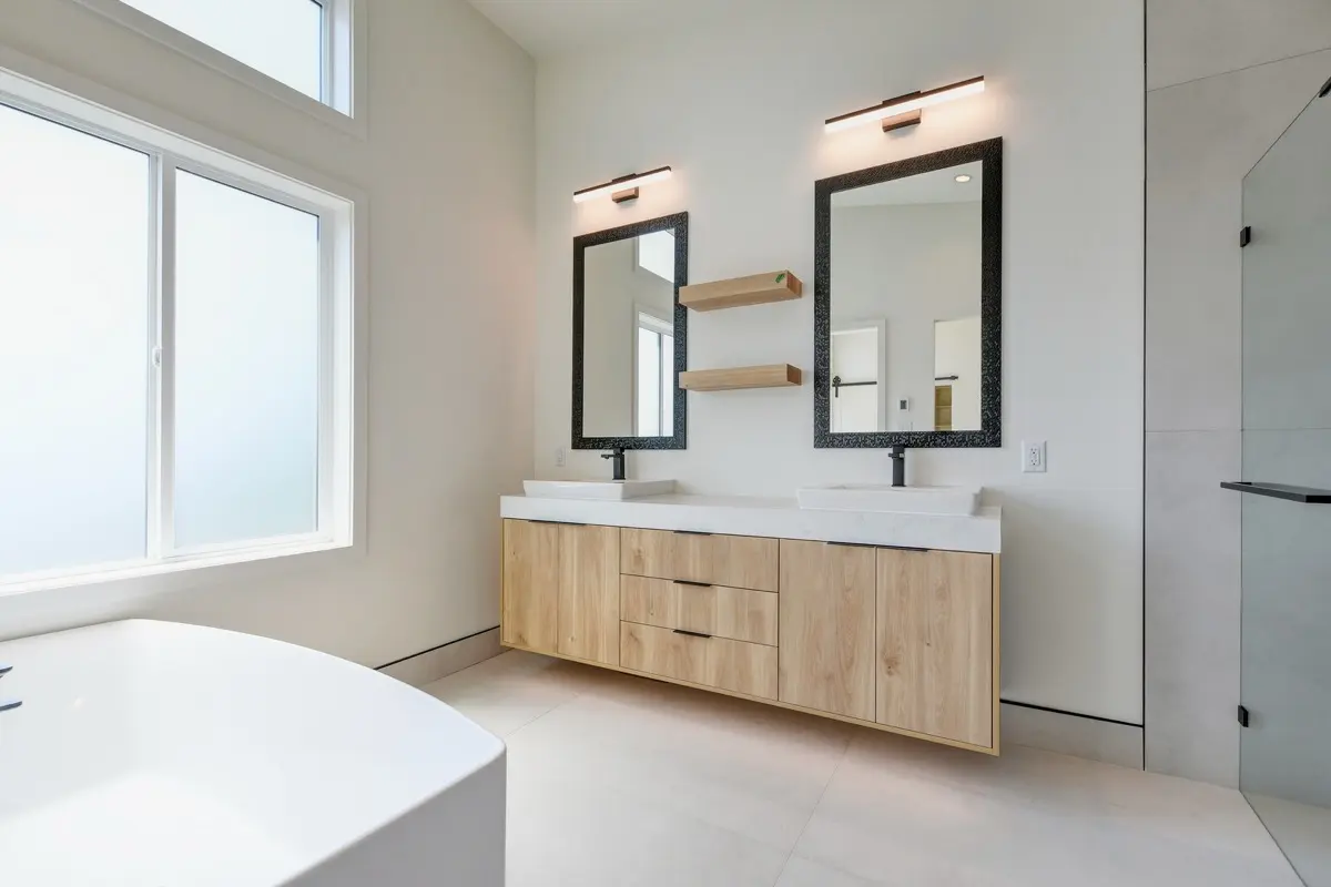 Primary ensuite with a double oak vanity and freestanding tub
