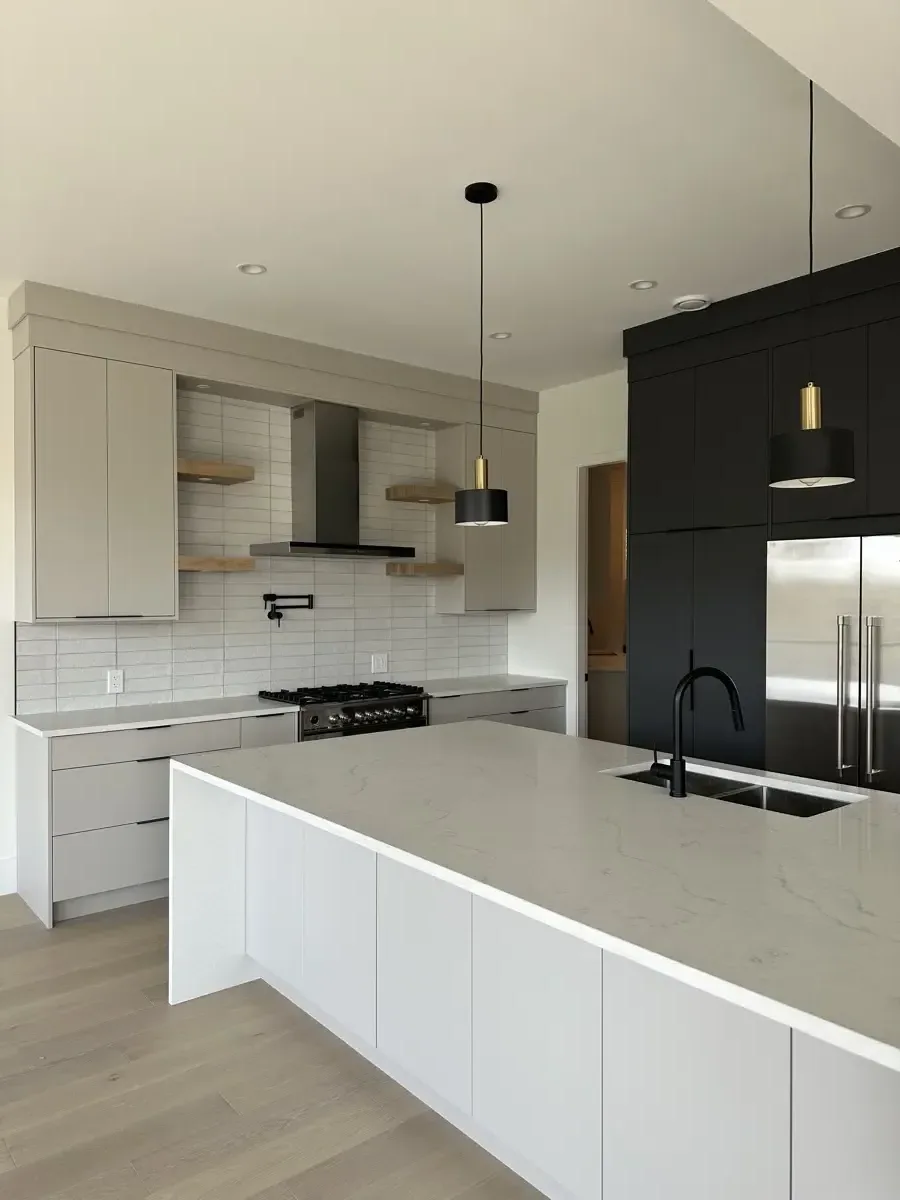 Contemporary kitchen with a marble waterfall island and matte-black cabinetry